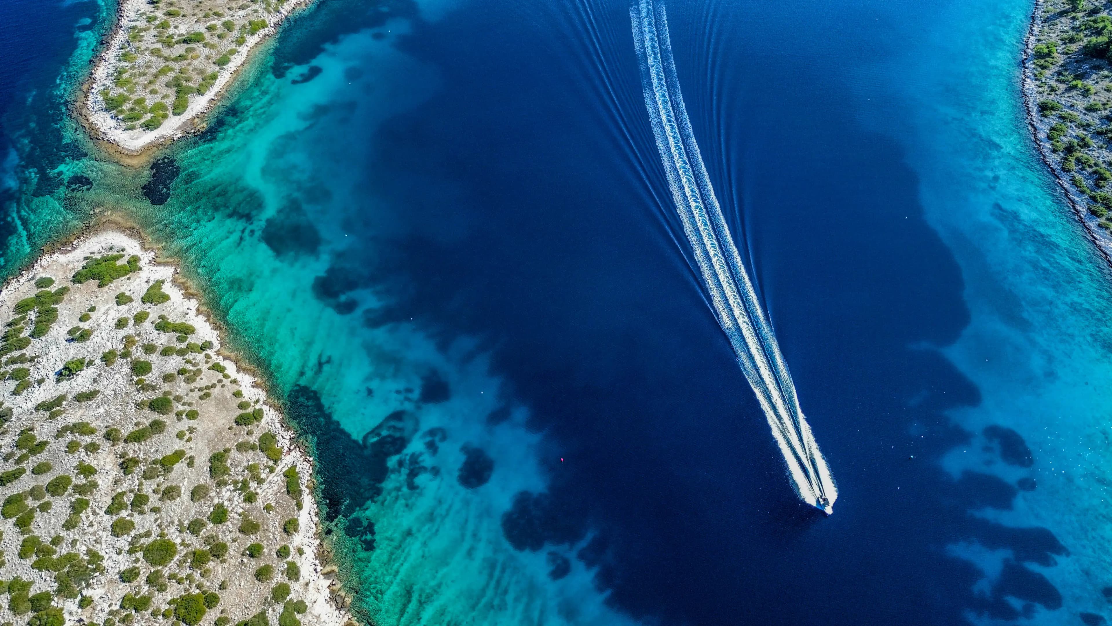 Łódź na turkusowej wodzie widziana z góry